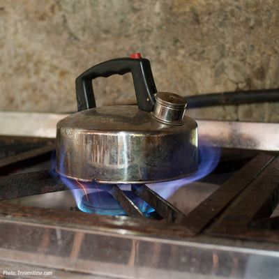 A kettle on a gas stovetop.