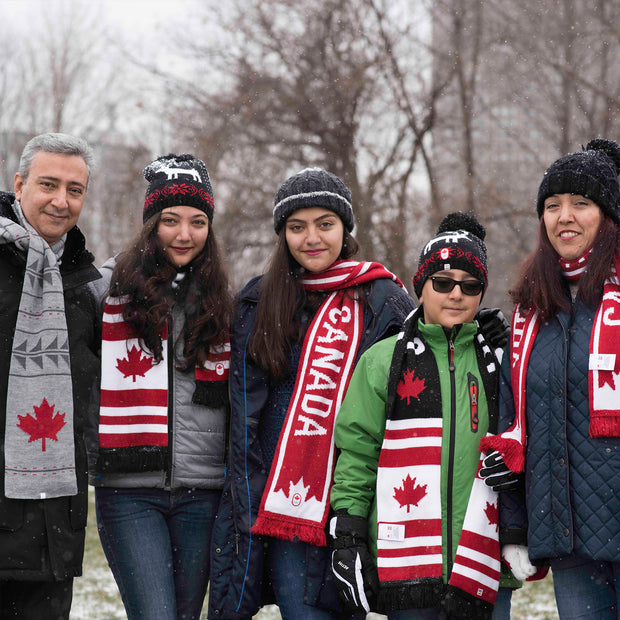 Five people posing for the camera wearing Canadian-themed clothing.